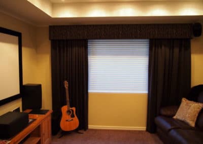Home theatre with dark curtains and venetian blinds