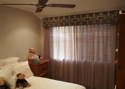 bedroom with damask pelmet and sheer curtains