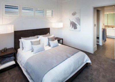 bedroom with narrow white shutters